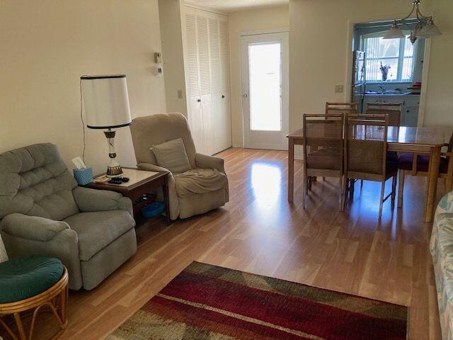 living room with a notable chandelier, a healthy amount of sunlight, and light hardwood / wood-style floors