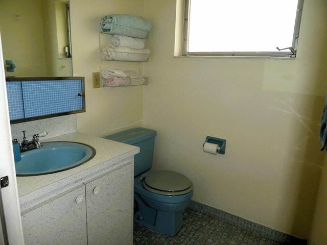 bathroom with toilet, tile floors, and vanity