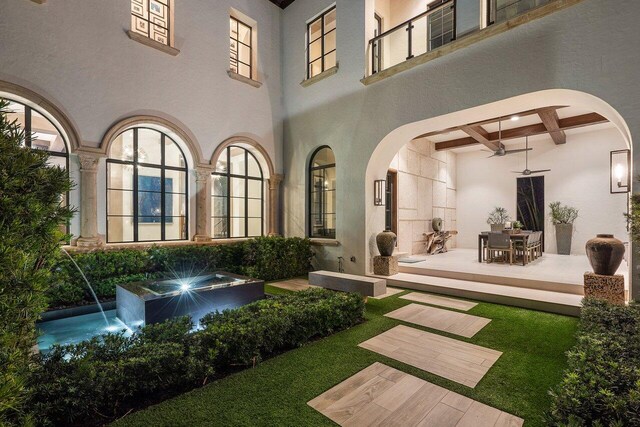 interior space featuring a high ceiling, coffered ceiling, and ceiling fan