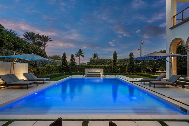 pool at dusk with a patio