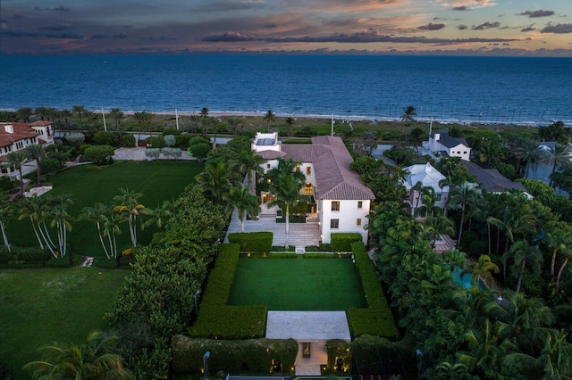 aerial view at dusk featuring a water view