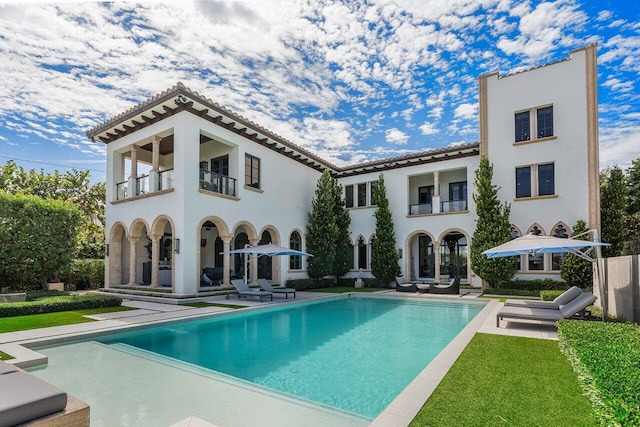 rear view of house with a balcony and a patio area