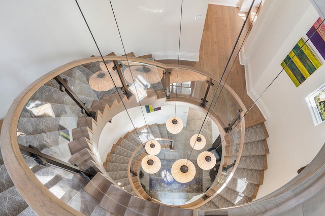 staircase with tile flooring and a towering ceiling