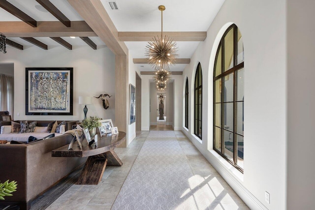 hall with light tile floors, beam ceiling, a chandelier, and french doors