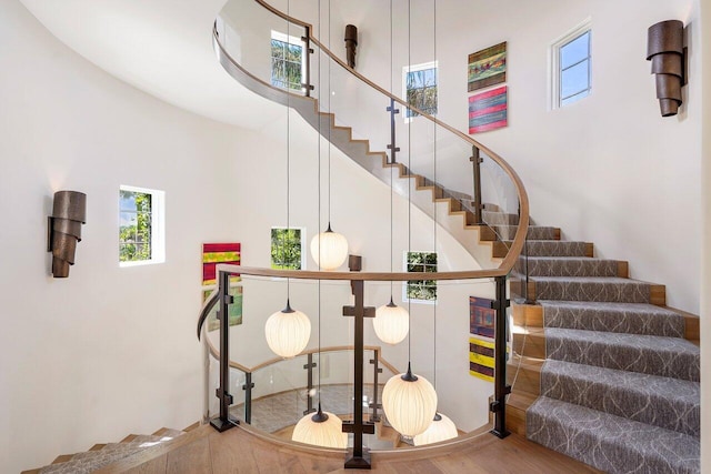 stairway with a high ceiling and hardwood / wood-style flooring