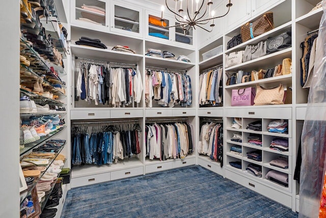 walk in closet featuring a notable chandelier and dark colored carpet