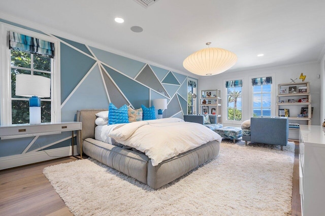 bedroom with ornamental molding and wood-type flooring