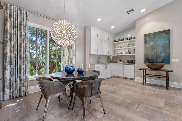 dining space with an inviting chandelier, lofted ceiling, and light hardwood / wood-style floors