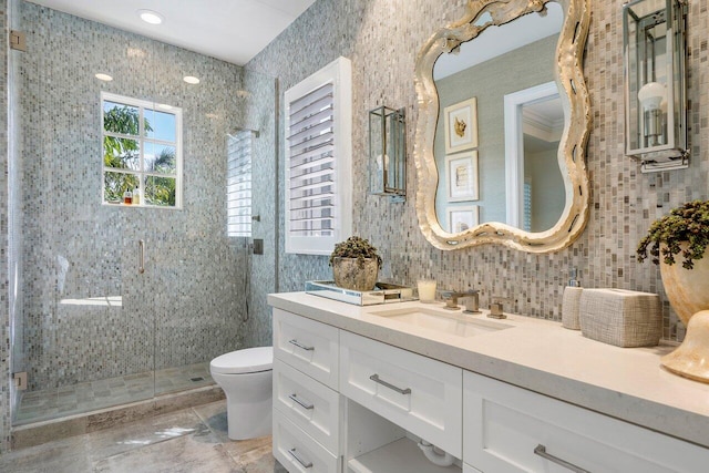 bathroom with tile walls, toilet, a shower with door, tile flooring, and oversized vanity