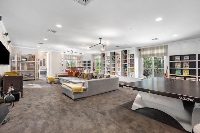 carpeted living room with a notable chandelier and ornamental molding