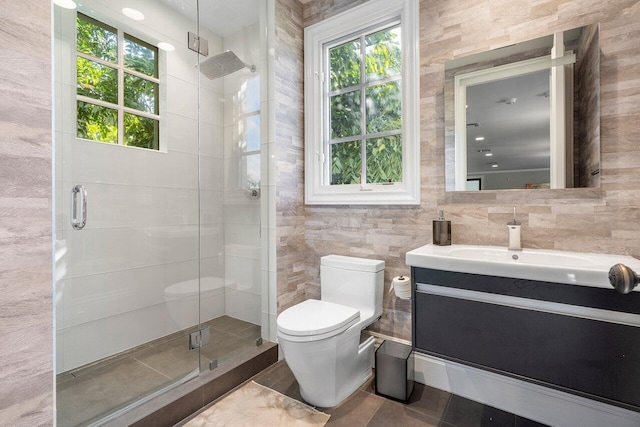 bathroom featuring tile walls, toilet, an enclosed shower, tile flooring, and vanity