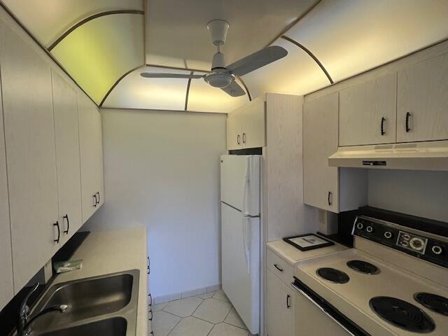 kitchen featuring sink, white appliances, light tile patterned floors, and ceiling fan