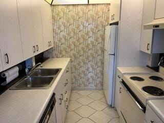 kitchen with sink, light tile floors, white refrigerator, white cabinets, and stainless steel dishwasher