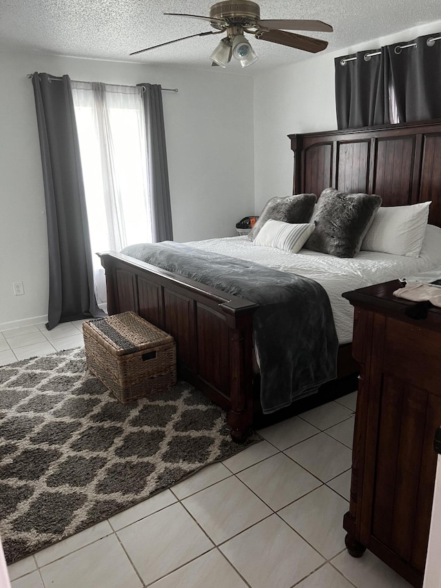 tiled bedroom featuring ceiling fan and a textured ceiling