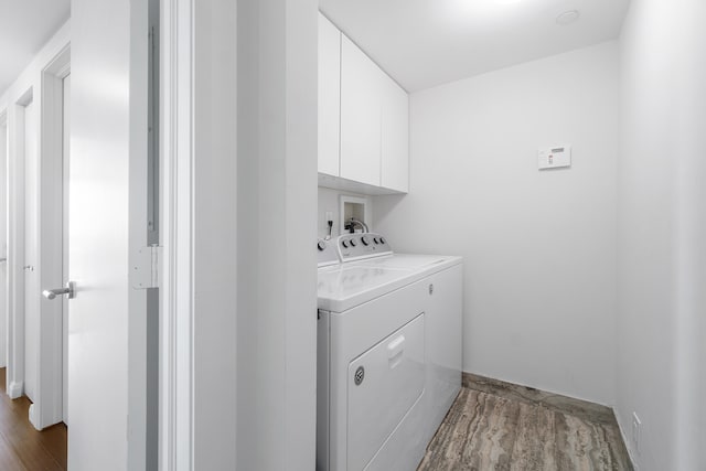 washroom featuring hookup for a washing machine, cabinets, washing machine and clothes dryer, and light wood-type flooring