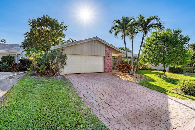 single story home featuring decorative driveway, brick siding, an attached garage, and a front lawn