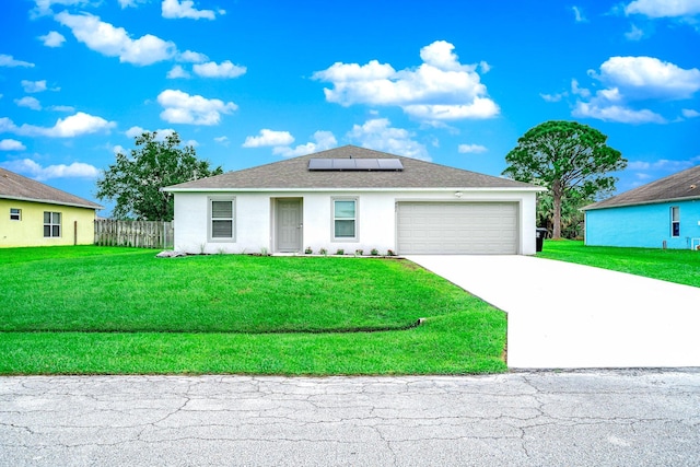 view of front of property featuring solar panels, a front lawn, and a garage