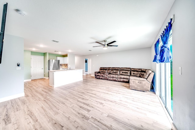 unfurnished living room with ceiling fan and light wood-type flooring