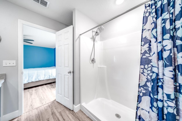 bathroom featuring curtained shower, hardwood / wood-style floors, and ceiling fan