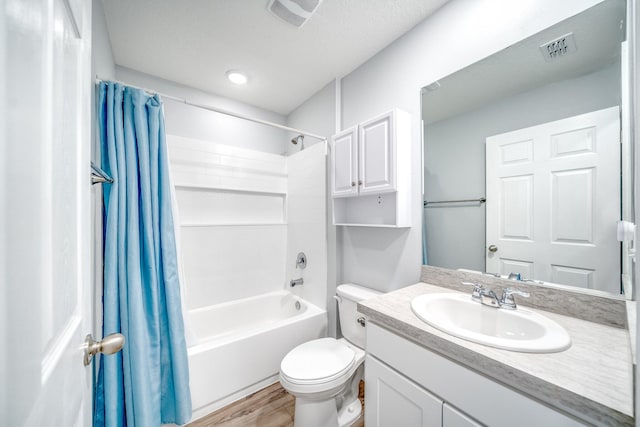 full bathroom featuring hardwood / wood-style floors, shower / bath combo, oversized vanity, and toilet