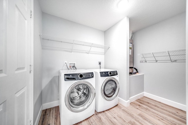 laundry area featuring washer hookup, hookup for an electric dryer, separate washer and dryer, and light hardwood / wood-style flooring