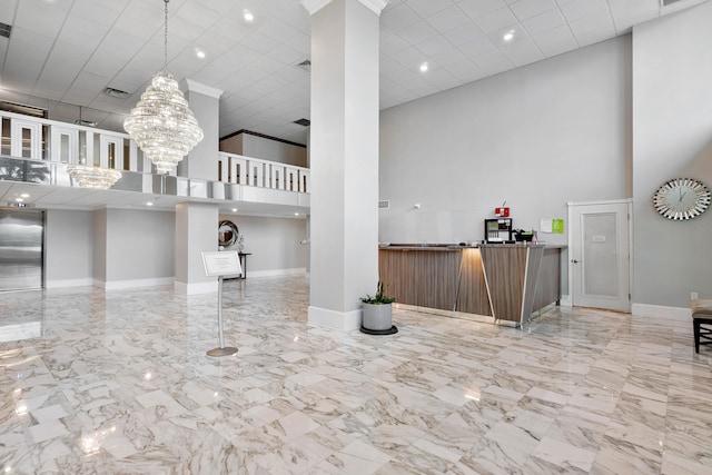 interior space with a notable chandelier, light tile floors, decorative light fixtures, a high ceiling, and elevator