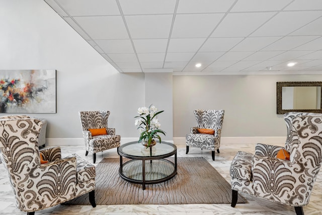 living area featuring a paneled ceiling