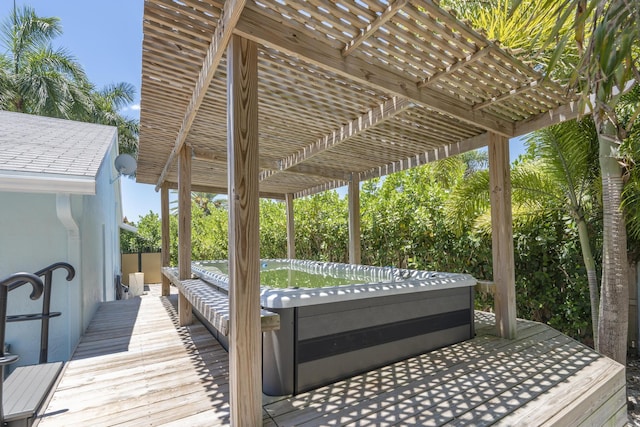 wooden deck with a pergola and a hot tub