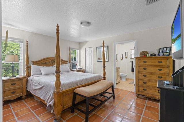 bedroom featuring connected bathroom, a closet, tile patterned floors, and multiple windows