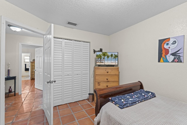 tiled bedroom featuring a textured ceiling and a closet