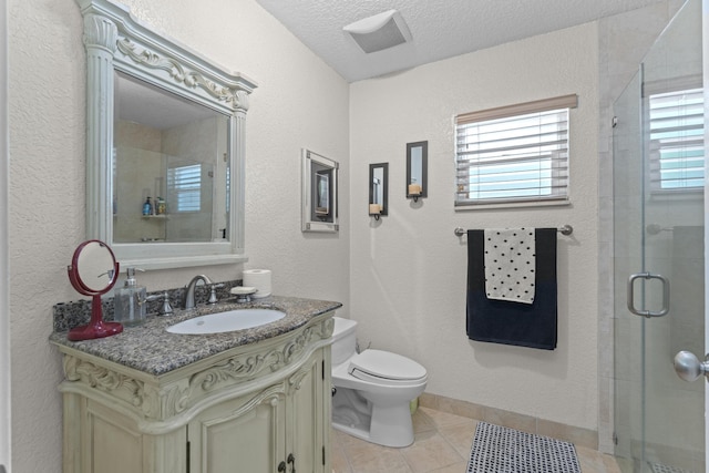 bathroom with tile patterned floors, an enclosed shower, a textured ceiling, toilet, and vanity