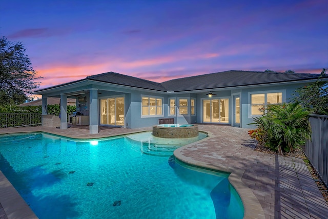 7186 SW Quiet River Ct, Stuart, FL 34997 - back of house at dusk with a patio, a tile roof, ceiling fan, and stucco siding