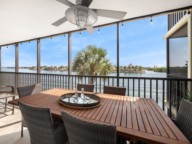 sunroom / solarium with a water view and ceiling fan