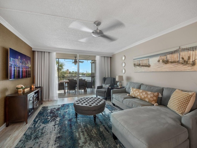 living room with ceiling fan, a textured ceiling, light wood-type flooring, and crown molding