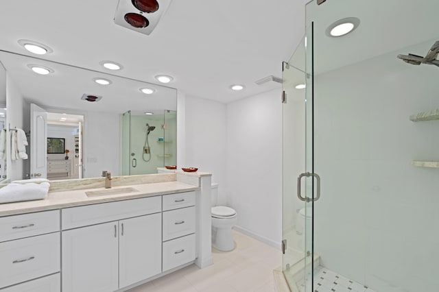 bathroom with toilet, a shower with door, tile floors, and vanity