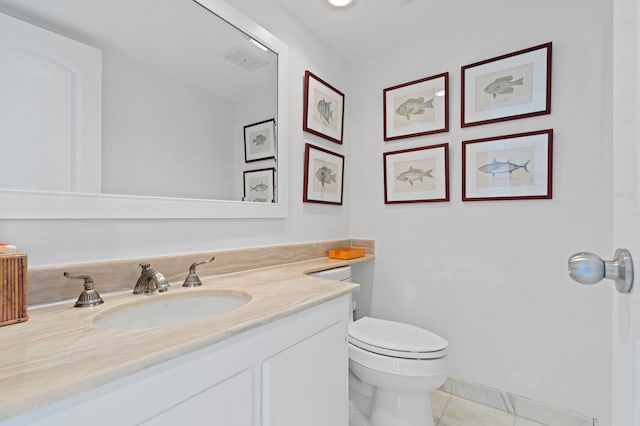 bathroom featuring vanity, tile flooring, and toilet