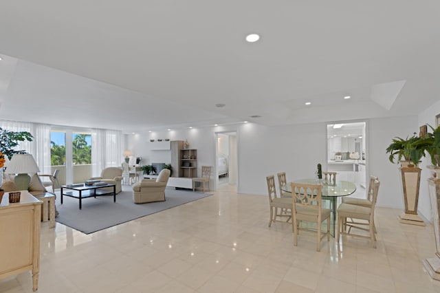 tiled dining space featuring a raised ceiling