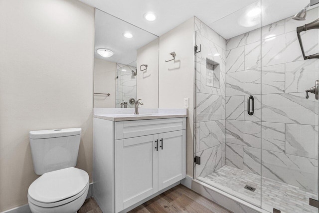 bathroom featuring vanity, hardwood / wood-style floors, walk in shower, and toilet