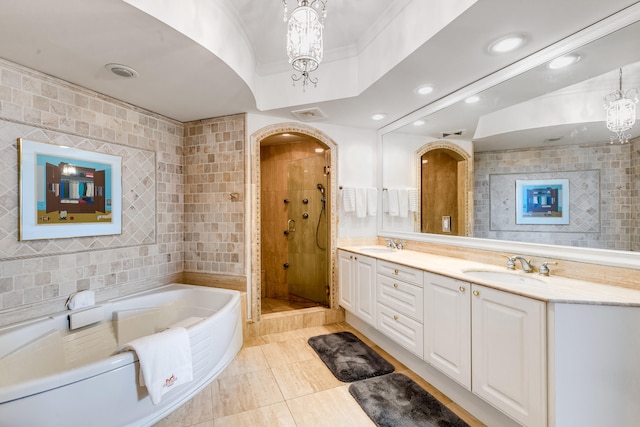 bathroom featuring tile walls, vanity with extensive cabinet space, a chandelier, tile flooring, and separate shower and tub