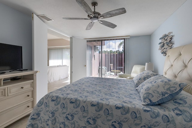 bedroom featuring a textured ceiling, access to exterior, and ceiling fan