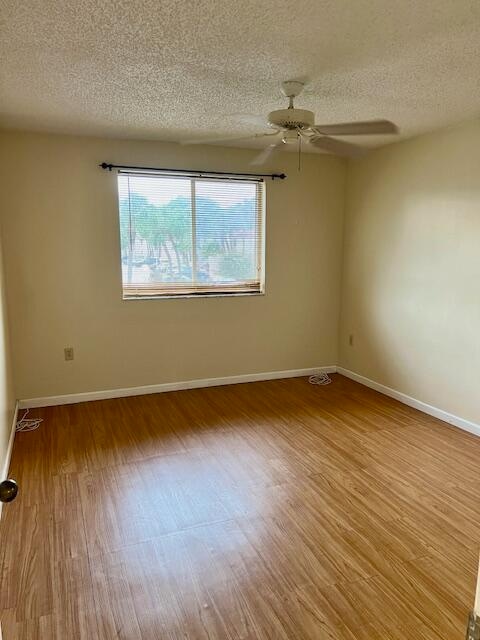 spare room with ceiling fan, hardwood / wood-style flooring, and a textured ceiling