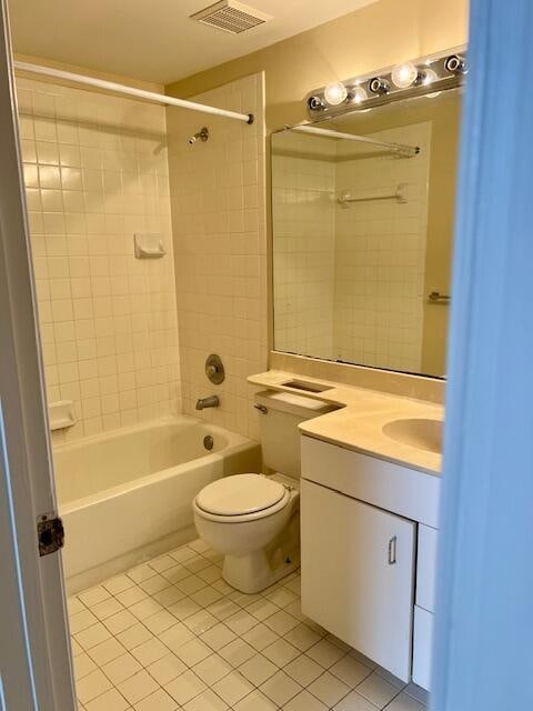 full bathroom with tile patterned floors, tiled shower / bath, toilet, and vanity