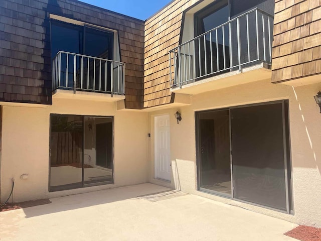 back of house featuring a balcony and a patio area