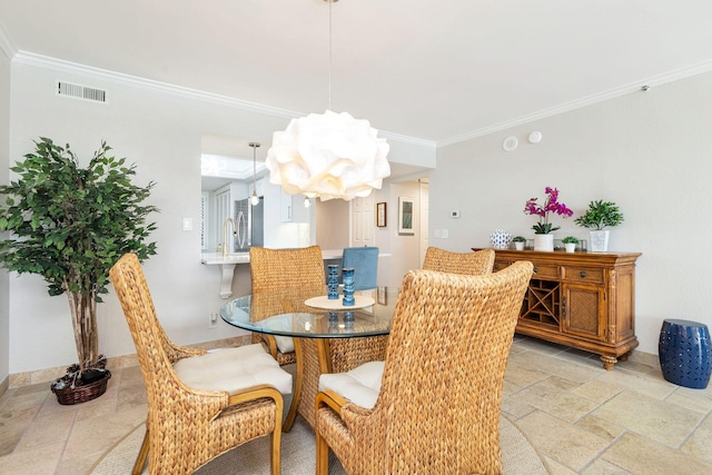 dining area featuring crown molding and a notable chandelier