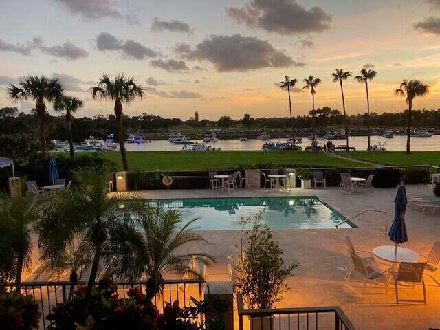 pool at dusk with a patio and a water view