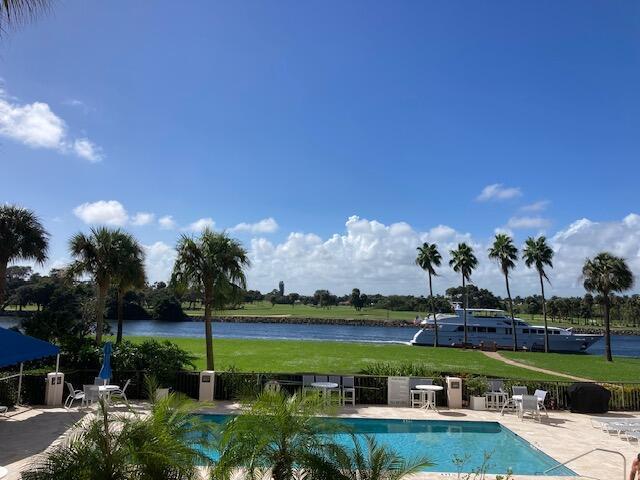 view of swimming pool featuring a water view and a patio