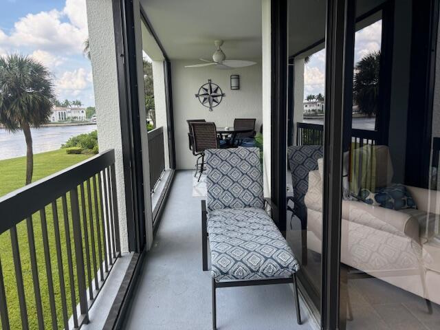 sunroom / solarium with a water view and ceiling fan