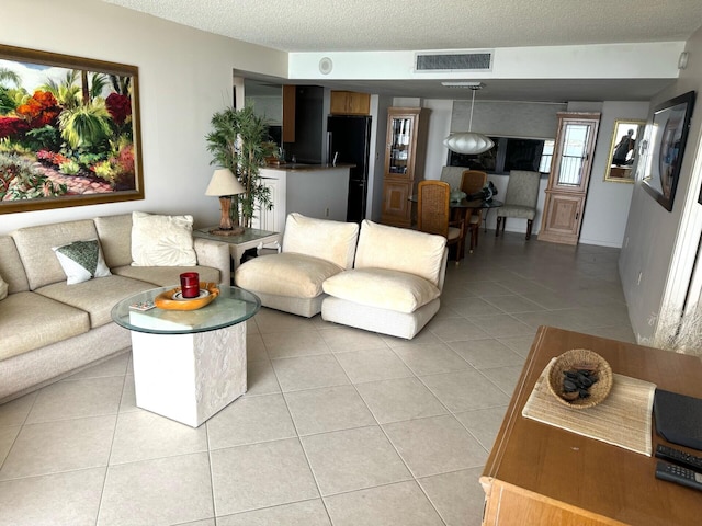 living room with a textured ceiling and light tile patterned floors