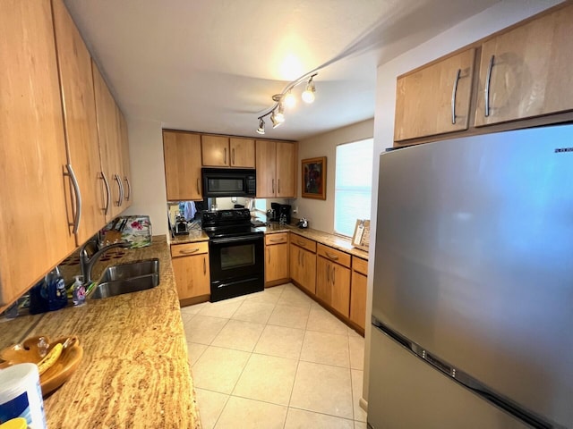 kitchen featuring rail lighting, light tile patterned floors, light stone countertops, black appliances, and sink