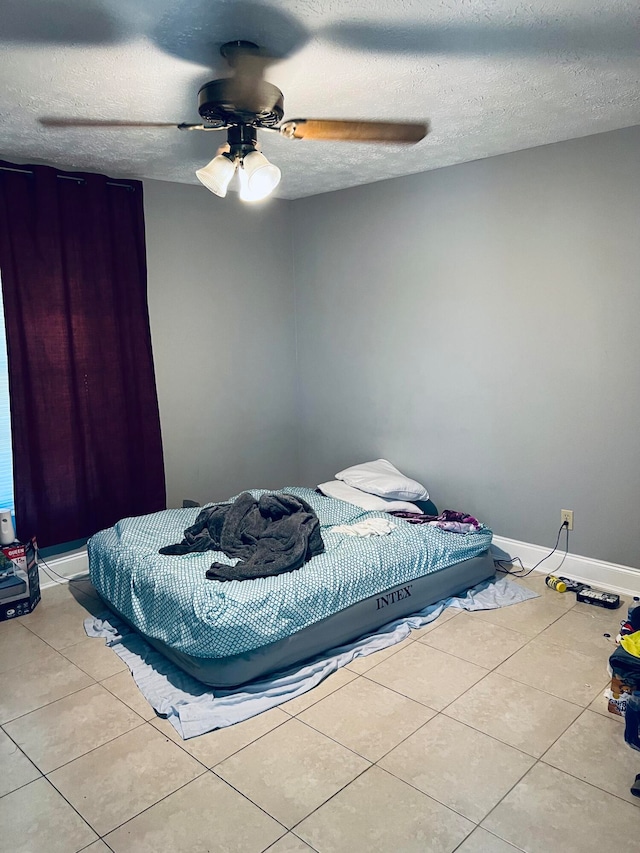 bedroom with light tile floors, a textured ceiling, and ceiling fan